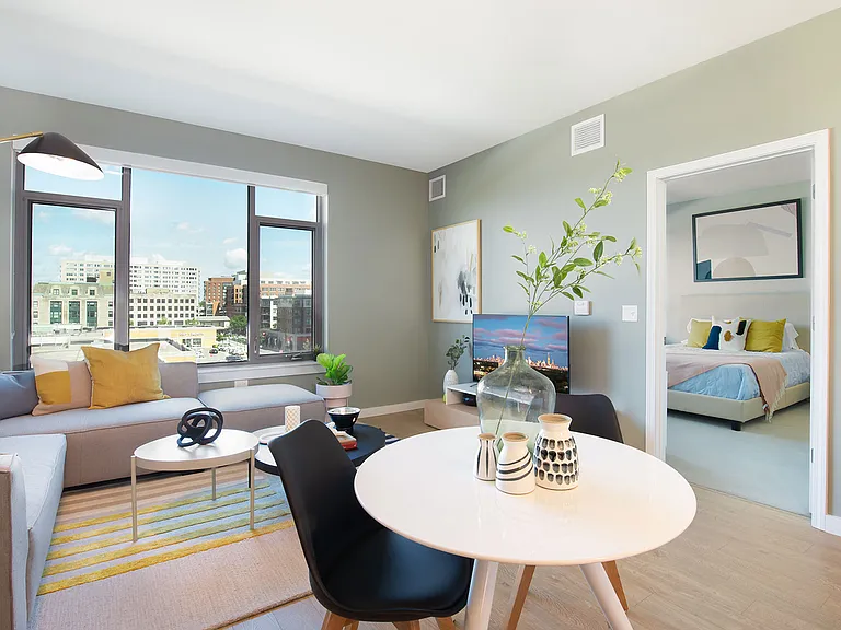 Bright and thoughtfully designed, this open living space at Eleven33 connects comfort and style with seamless flow from living room to bedroom and plenty of natural light.