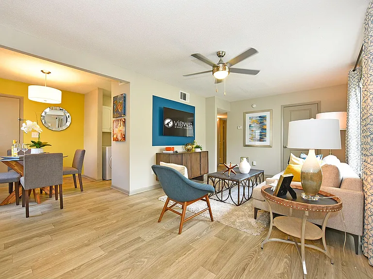 Spacious living room with hardwood-style flooring & ceiling fan