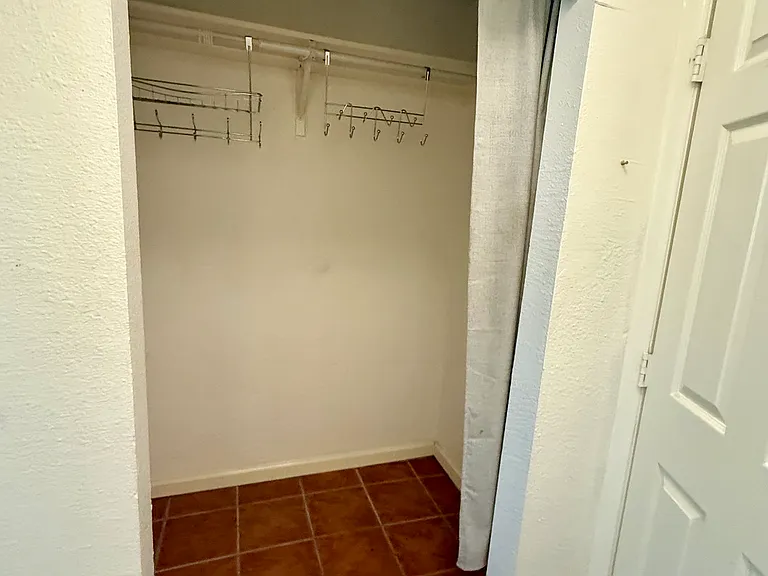 View of 3rd BR closet, directly across from bathroom; door on right opens back up into common kitchen area.