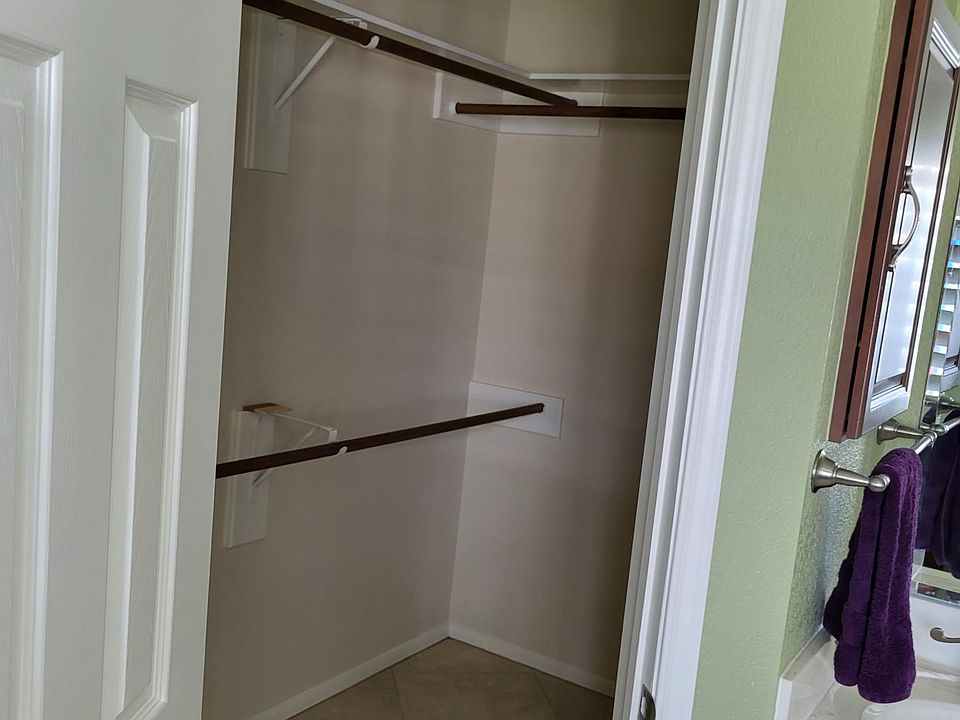 Master walk in closet within bathroom includes shelves in the back corner.