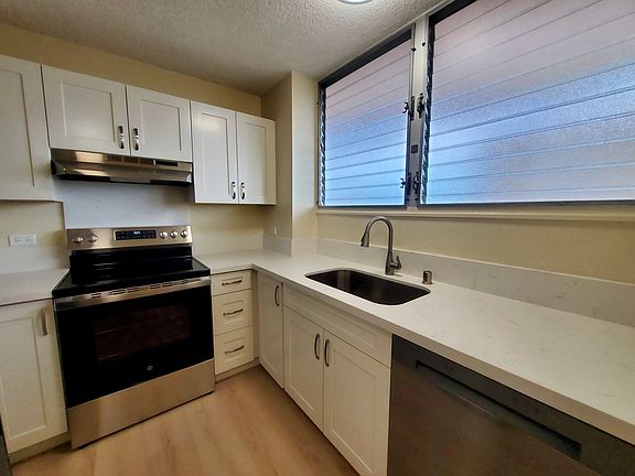 Fully renovated kitchen with new cabinets, quart countertops, and stainless steel range oven
