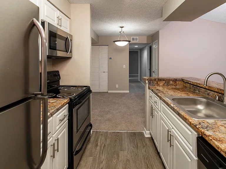 Begin your day in style with a kitchen that combines practicality and aestheticsa breakfast bar view of stainless-steel elegance and granite-style countertops.