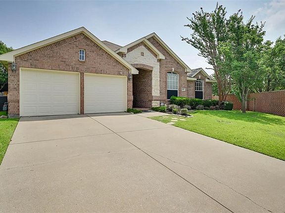 View of front of house with driveway, fence, a garage, brick siding, and a front yard