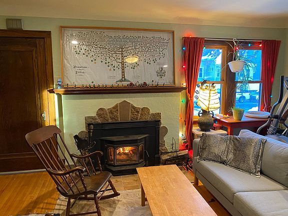 Living room with fireplace insert that uses real wood. Quarter sawn oak floors, new windows.