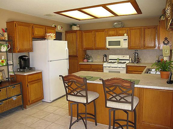 Incredible kitchen offers ceramic tile flooring, energy-efficient gas oven/range & handy built-in microwave, abundant cabinetry & counter space galore, & breakfast bar! Large window with 2" blinds brings the outdoors in! A true chef's delight!