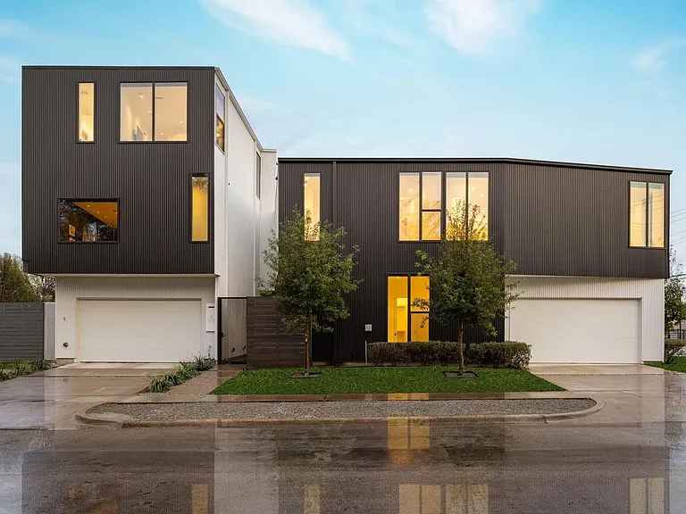 Contemporary multi-story facade featuring dark paneling and white stucco accents