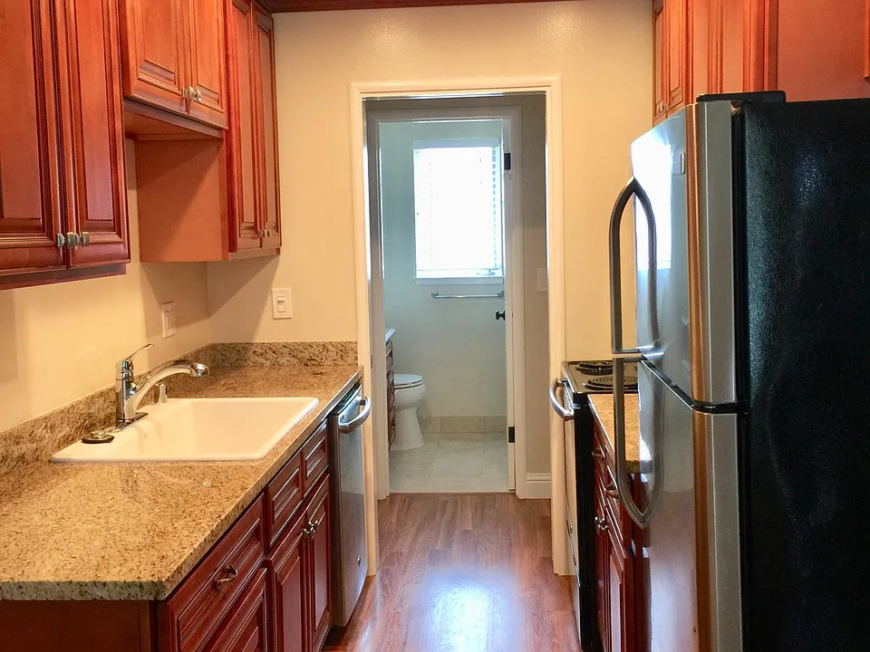 Gourmet Kitchen includes large cast iron sink, granite countertops, lots of cabinet space, stainless steel microwave, oven, refrigerator, microwave, dishwasher, hardwood floor, recessed LED dimmer lighting, pocket door to close off