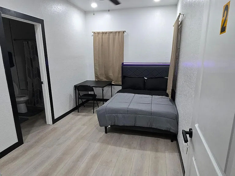 Private furnished bedroom 2 with ceiling fan and a compact desk area; includes convenient access to ensuite bathroom