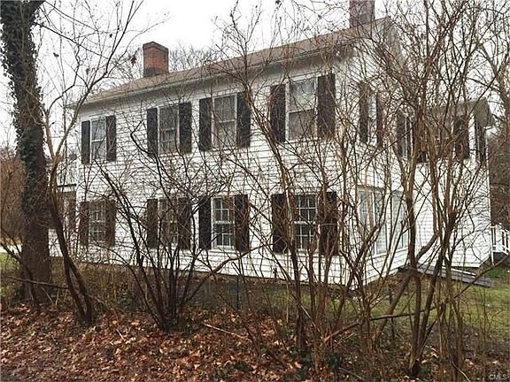 The is the familiar view of the white antique through a now bare lilac hedge.