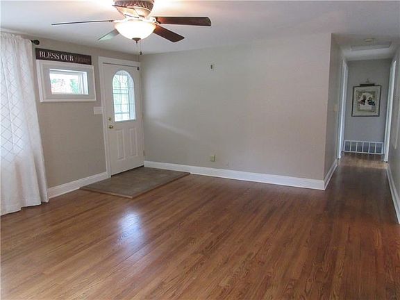 Living room features a 4 x 5 ft ceramic tile entry, beautifully refinished hardwood floors, two picture windows, and a ceiling fan with a light.