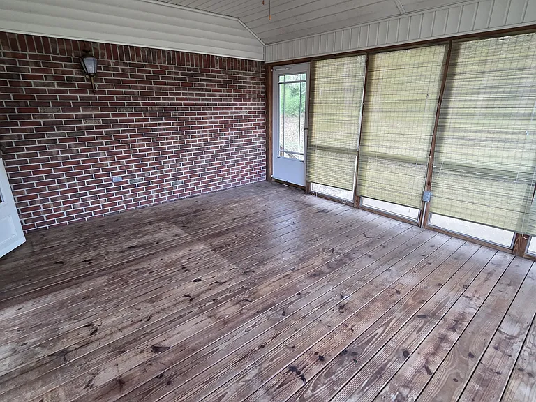Screened in patio with ceiling fan and privacy shades.