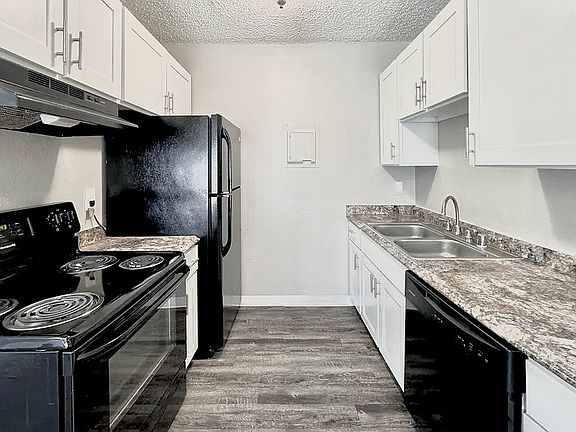 Cook up your favorite meals in a kitchen that's as stylish as it is functional, complete with sleek, black appliances.