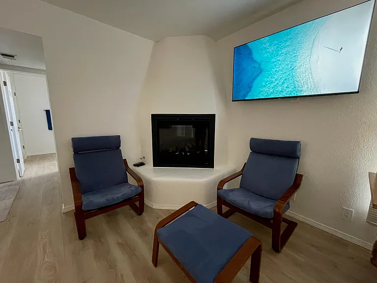 Primary bedroom gas modern kiva fireplace and seating area