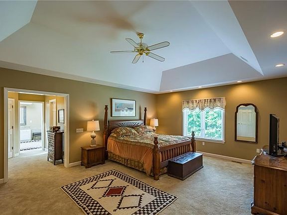 Master suite with tray ceiling, complete with large walk-in closet, linen closet, captive nursery/office/gym space, vanity area 