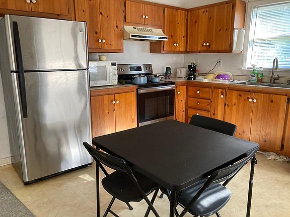 Spacious kitchen with upgrade stainless steel refrigerator and stove.