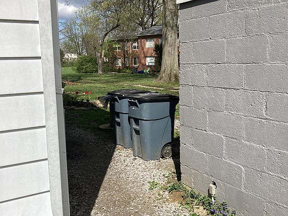 Pathway between the bldg and the garage...where the trash cans SHOULD go!