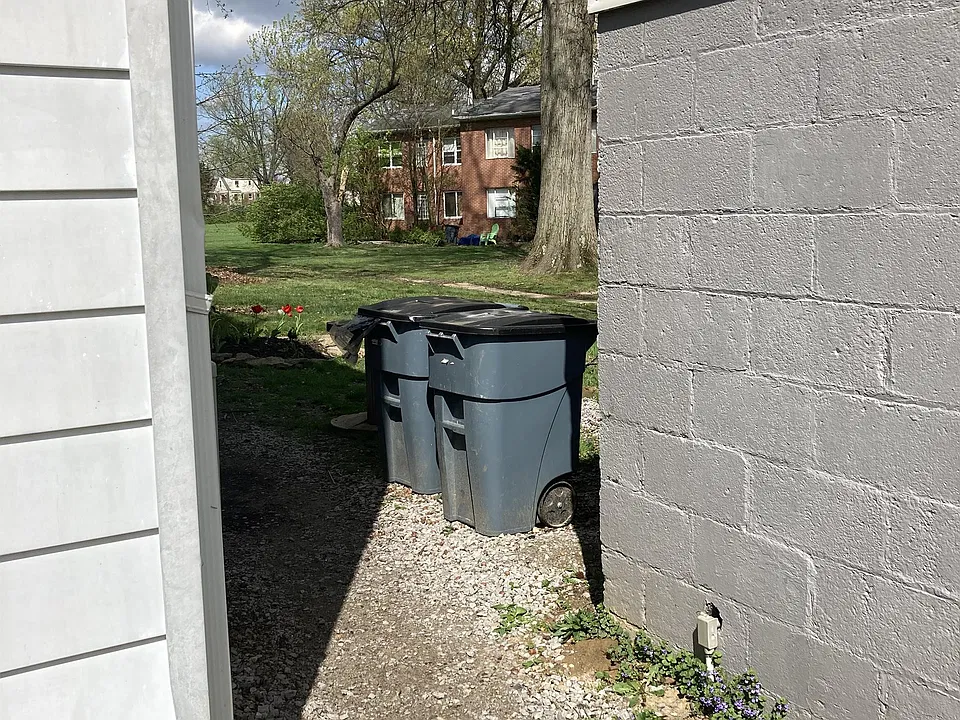 Pathway between the bldg and the garage...where the trash cans SHOULD go!