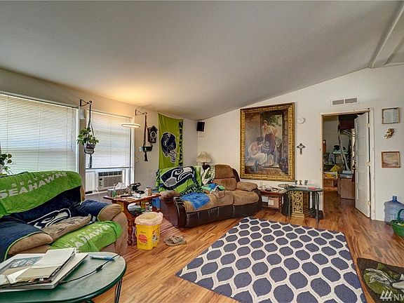 The living room has a large picture window, easy care flooring and vaulted ceilings. 