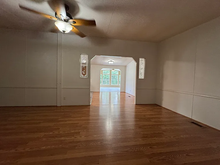 Bright, oversized living room featuring hardwood floors, a large bay window overlooking the front yard, and direct access to the front porch. Plenty of space for family gatherings and everyday living.