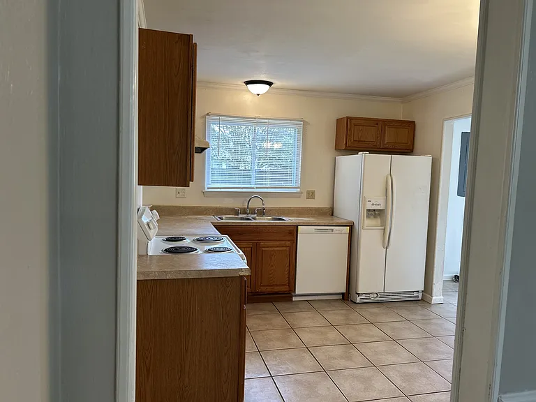 Kitchen with white appliances: Stove, dishwasher & Refrigerator