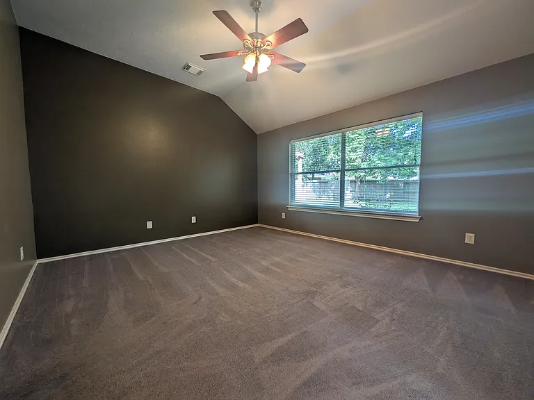 High ceilings and a large double window create a light-filled atmosphere, offering plenty of wall space for a king-size bed and full bedroom setup.