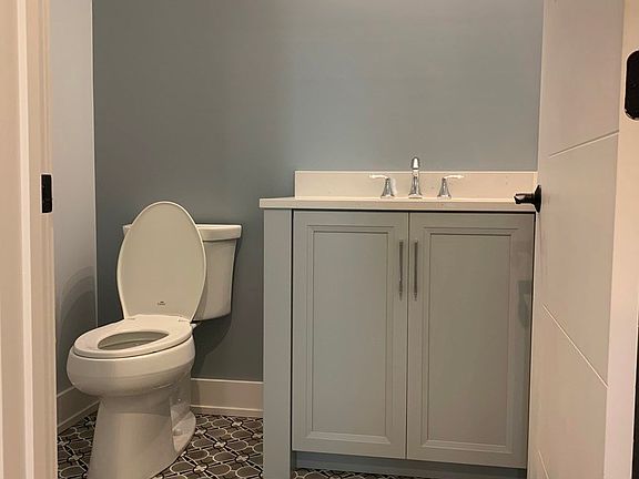 discreet first floor powder room with modern concrete floor tiles