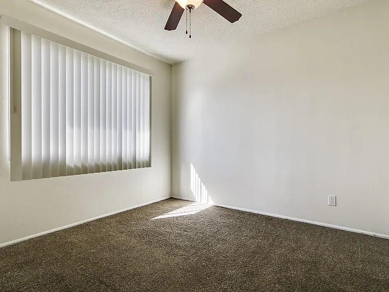 Bedroom With ceiling fan and caperted flooring