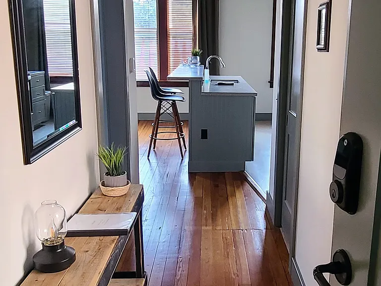 Hallway looking into your apartment. Bedroom is the first door on the left. A spacious walk-in closet is the door to the right, with a full bathroom accessed from a door that's not in this photo. The living room/kitchen/island is open concept