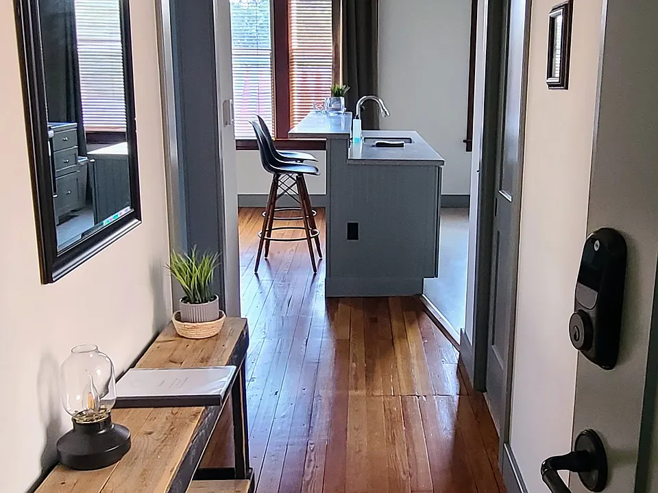 Hallway looking into your apartment. Bedroom is the first door on the left. A spacious walk-in closet is the door to the right, with a full bathroom accessed from a door that's not in this photo. The living room/kitchen/island is open concept