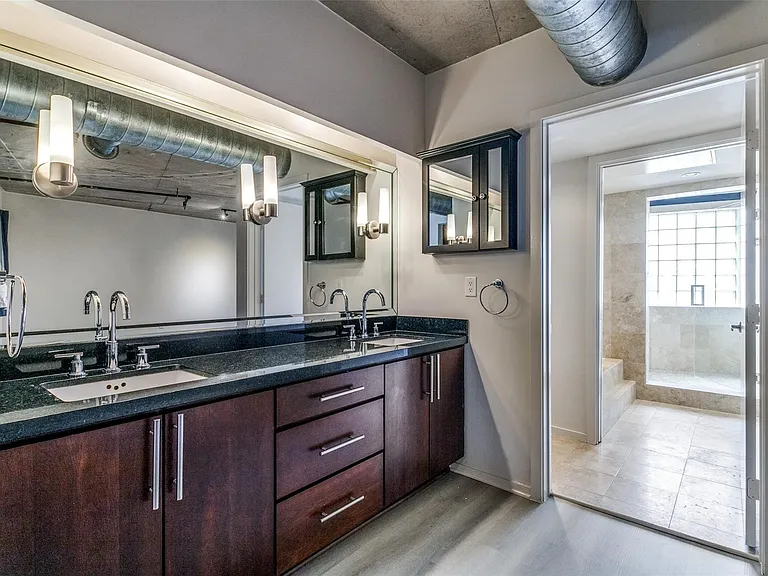 Dual vanity with a dark wood-finish cabinet and stone countertop