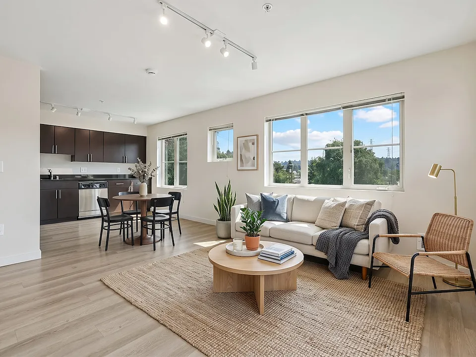 Bright open layout connecting the living room and dining space to the kitchen at REV Fremont in Seattle.