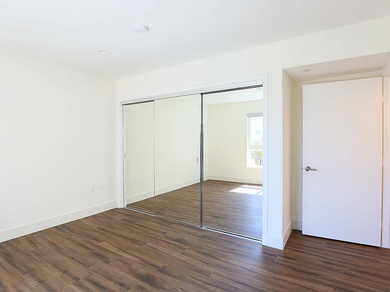 Bedroom with Mirrored Closet and Vinyl Flooring