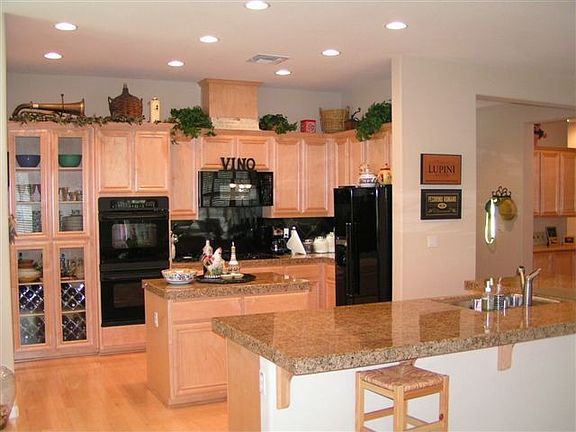 kitchen with maple cabinets, maple floors, granite tile counters 