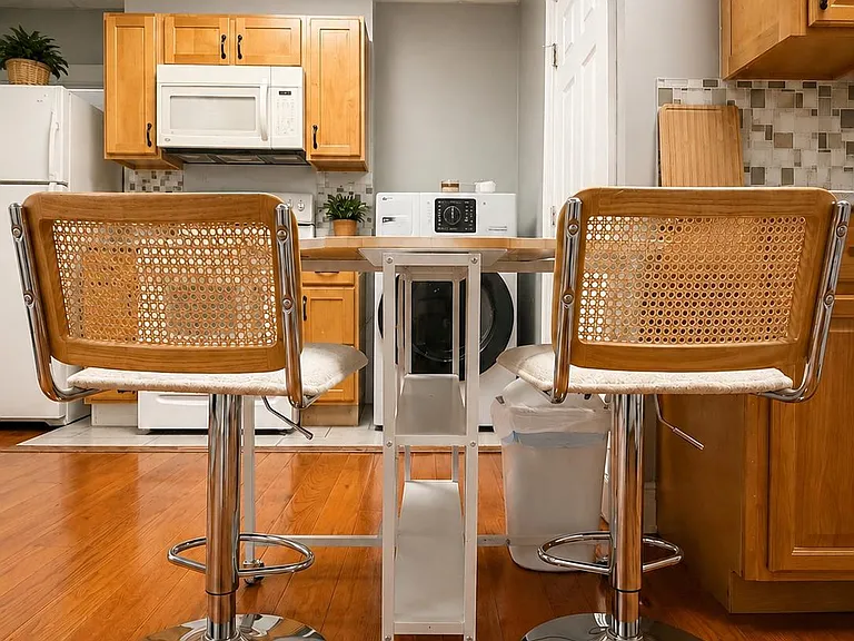 Kitchen features ample wood cabinetry, full-size appliances, and a compact dining island for everyday meals.