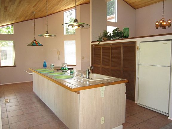 The open kitchen features a huge island, kitchen eating space and plenty of storate. The dining room sits above the cathedral ceiling ledge.
