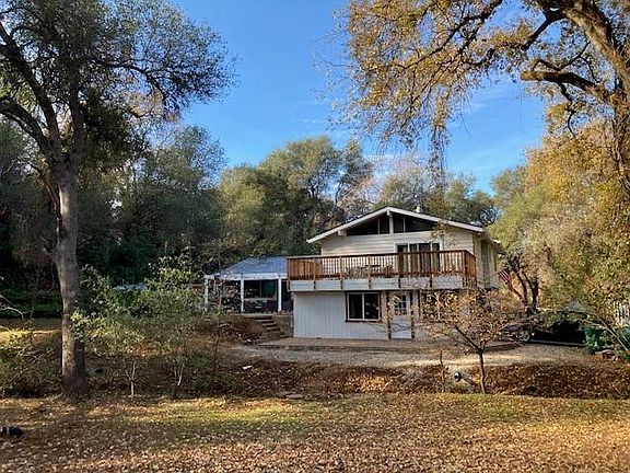 View of home from street, the redwood deck is outside the master bedroom, the flagstone deck is outside of bedroom #4, in front is a seasonal creek