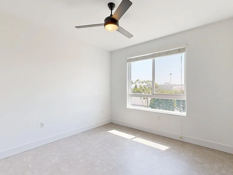 Spacious apartment bedroom with wood style floor.