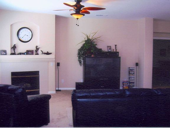 Living room with fireplace and ceiling fan