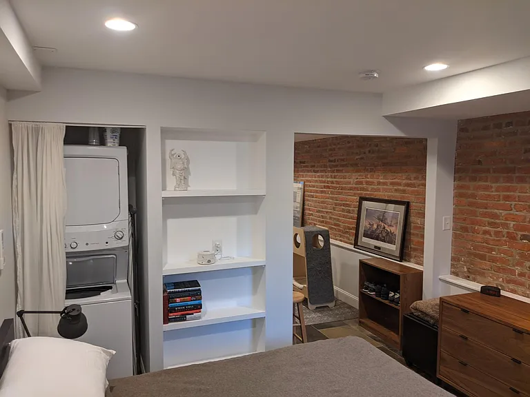 built-in shelves for books or trinkets, stacked in-unit washer/dryer