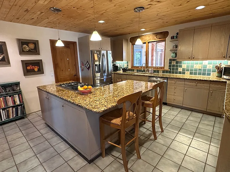 Large kitchen has double oven, pantry newer appliances, desk, well stocked with dishes and cooking utensils