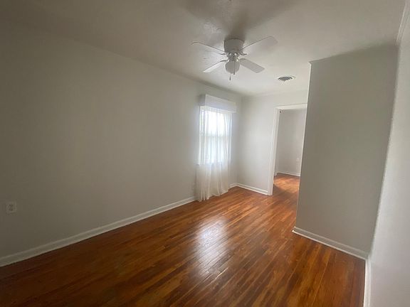 One of three bedrooms. All have ceiling fans, wood floors