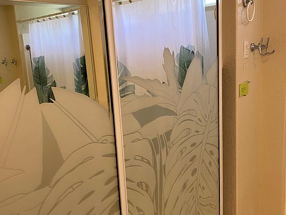 Decorative sliding glass door, where the washer/dryer and bath towels are located behind these doors in the bathroom.