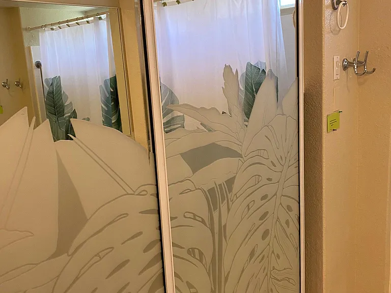 Decorative sliding glass door, where the washer/dryer and bath towels are located behind these doors in the bathroom.