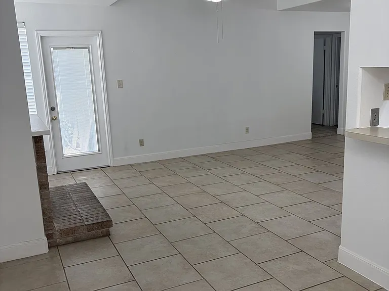 View from dining area to living area, door to backyard, door way to secondary bedrooms