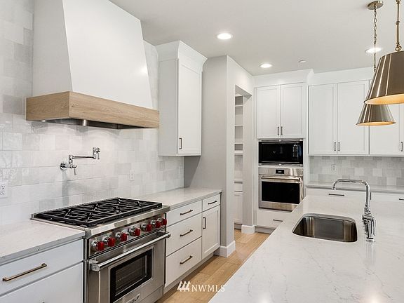 Tustin plan 4358 SF plan on Lot 8 is Under Construction with an end of Dec. completion.  Photos are of a different plan, but the similar colors and finishes are representative of the homes at Clyde Estates. The photo is an example of the Wolf 6-burner /oven, pot-filler faucet and Wolf microwave & oven. The Tustin plan has a different kitchen layout. Color, design, details and finishes are subject to change.