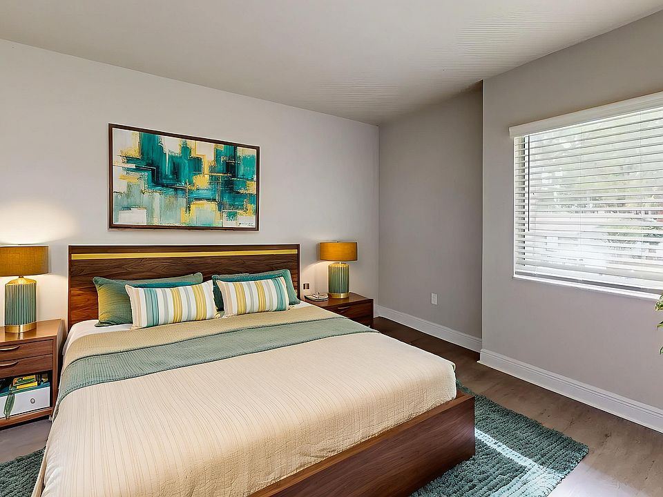 Bright and modern bedroom with stylish decor, featuring a cozy bed, elegant lamps, and vibrant wall art.