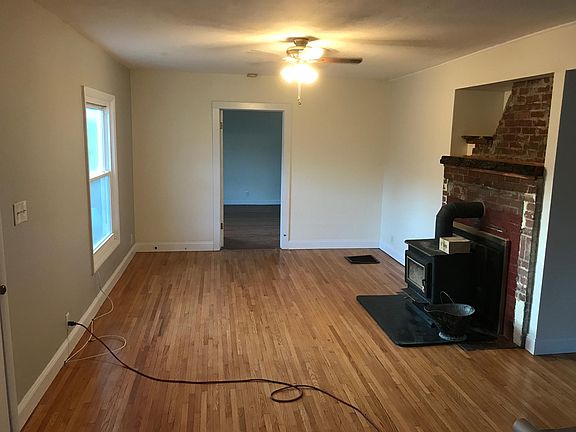 Kitchen area flows into main living area. Note: wood stove w