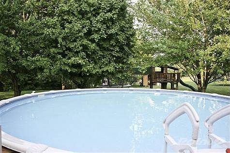 HUGE back yard with nice deck, Steps going into the pool, and 2 buildings for storage.