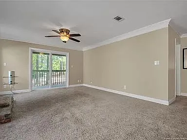 Spacious living room with access to the balcony with tree lined view.