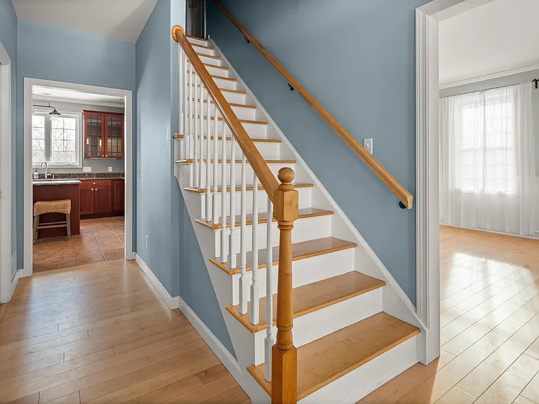 View from the main entryway. Upstairs access, coat closet and powder room to the left, formal sitting room and dining room to the right, kitchen straight ahead.